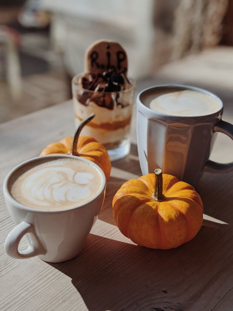 White coffee cup with pumpkins and RIP biscuit